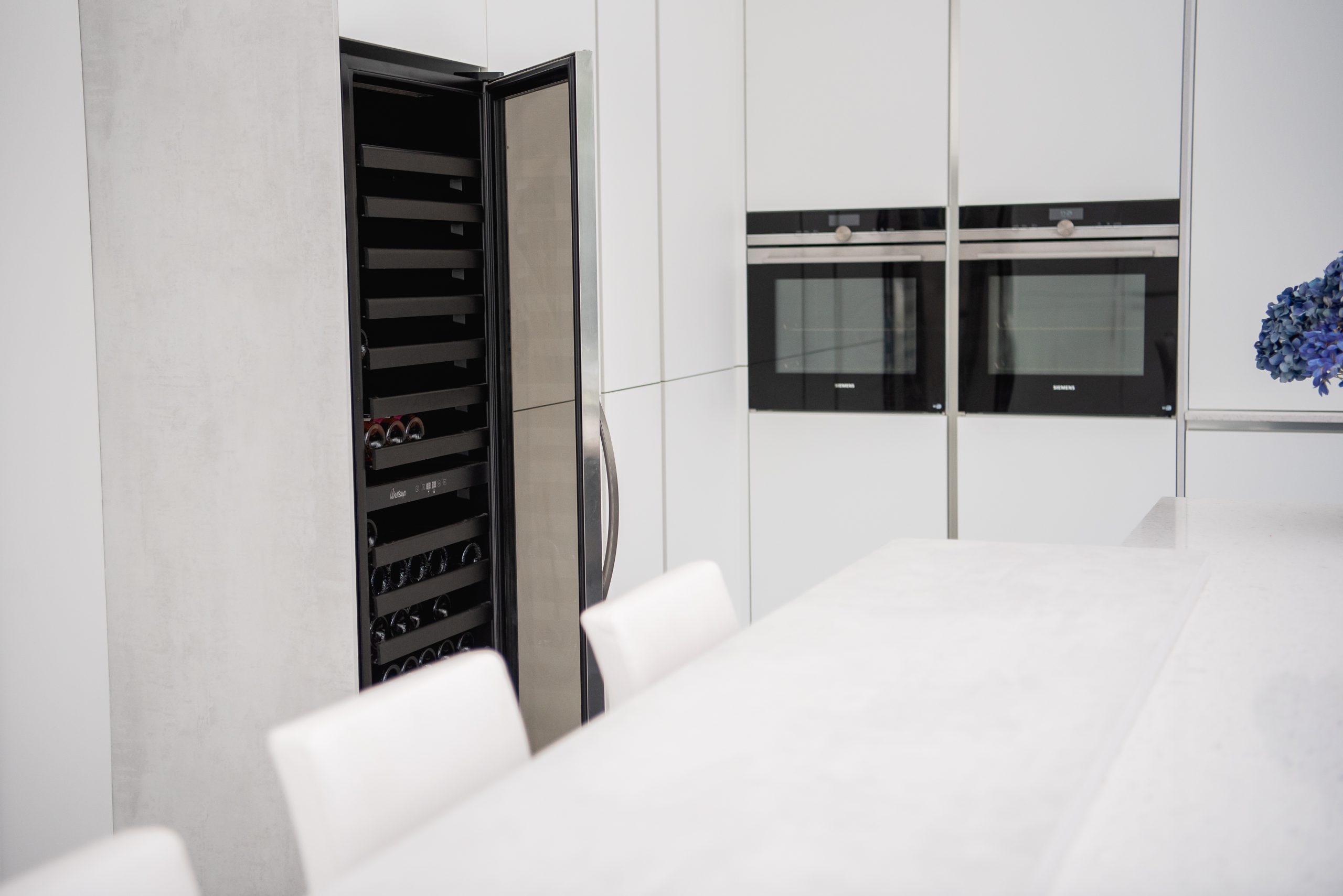 White kitchen island with wine fridge